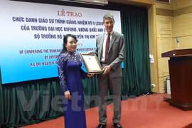 英国驻越大使贾尔斯·莱韦向越南卫生部部长阮氏金进授予牛津大学的客座教授荣誉称号。
