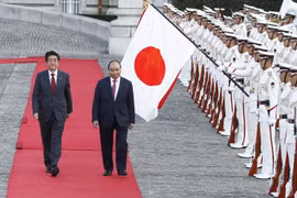 日本首相安倍晋三和越南政府总理阮春福（右）检阅仪仗队。（图片来源：越通社）