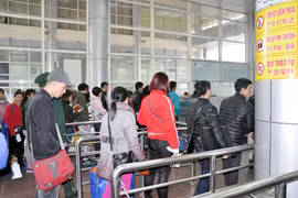 游客们在芒街口岸办理出境手续。