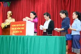 旅居老挝越南人社群为受灾群众捐款。（图片来源：越通社）