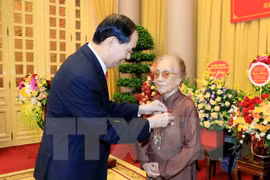 陈大光向前国家副主席阮氏萍颁发70年党龄纪念章。（图片来源：越通社）