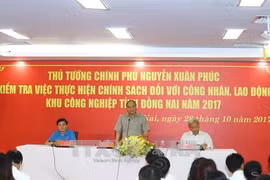 越南政府总理阮春福与同奈省各工业区劳动者进行对话。（图片来源：越通社）