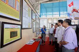 展会讲解员向参观者介绍各资料。（图片来源：越通社）