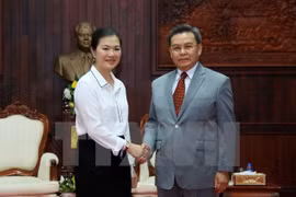 越南祖国阵线中央委员会副主席张氏玉映女士与老挝建国阵线中央主席赛宋蓬·丰威汉亲切握手。