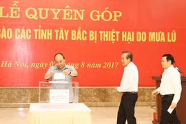 政府总理阮春福向灾民捐款。（图片来源：越通社）