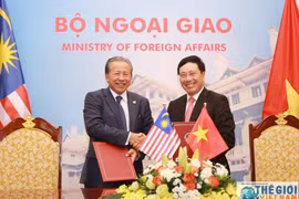 越南政府副总理范平明（右）和马来西亚外交部长阿尼法（图：baoquocte.vn） 