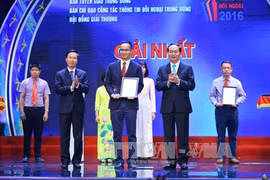 国家主席陈大光和中央宣教部部长武文赏向获一等奖的作者颁奖。