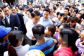 河内市人民委员会主席阮德钟与同心乡居民。（图片来源：越通社）