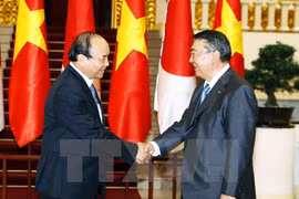 越南政府总理阮春福（左）与日本国会众议院议长大岛理森（右）亲切握手。