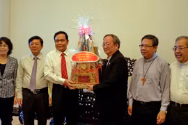 越南祖国阵线中央委员会主席向越南天主教胡志明市教区总主教裴文读总主教赠送礼物。（图片来源：越通社）