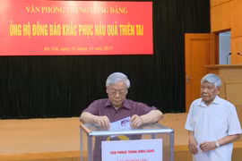 越共中央总书记阮富仲为各省水灾灾民捐款。