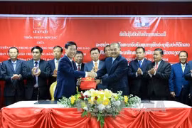 武文赏（左）与吉乔•开坎佩吞（右）签署了2016-2020年阶段越共中央宣教部与老挝人民革命党宣传部间的合作协议。（图片来源：越通社）