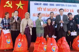 越南祖国阵线中央委员会副主席兼秘书长武仲金向广南省升平县平朝贫困户赠送慰问品