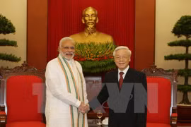 越共中央总书记阮富仲​与印度总理纳伦德拉•莫迪亲切握手（图片来源：越通社）
