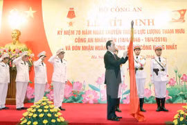 越南国家主席陈大光把一级军功勋章佩戴在公安部办公厅的传统旗上（图片来源：越通社）