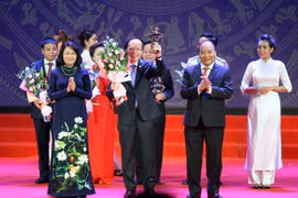 越南国家主席邓氏玉盛和政府总理阮春福向典范企业家授予喠圣奖杯（图片来源：越通社-VNA）