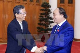 越南政府总理阮春福与世行驻越首席代表维多利亚·克瓦亲切握手（图片来源：越通社）