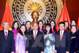 阮春福总理与越南驻华大使馆干部人员及旅居北京越南人社群​合影（图片来源：越通社）