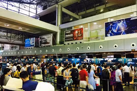 因遭黑客攻陷，内排国际机场航班显示屏一同关闭，诸多乘客正在等待办理登记手续。