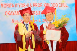 顺化大学校长阮文全向斗金哲教授授予名誉博士学位证书（图片来源：越通社）