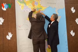 越南驻乌克兰大使阮明智与乌克兰—越南友好协会主席亚历山大将纸鸽子贴在越南地图上。