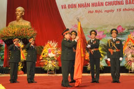 国防部长吴春历大将把一级祖国捍卫勋章佩戴在军医局的决胜旗上（图片来源：越通社）