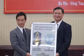 泉大津市代表团团长、市长南健一向巴地头顿省人民委员会副主席阮功荣赠送纪念品。图自越通社
