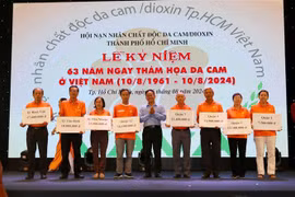 胡志明市越南祖国阵线委员会领导向橙剂受害者儿童代表颁发助学金。图自越通社