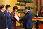 政府党委书记、政府总理范明政向越通社社长武越庄颁发政府党委的奖状。图自越通社