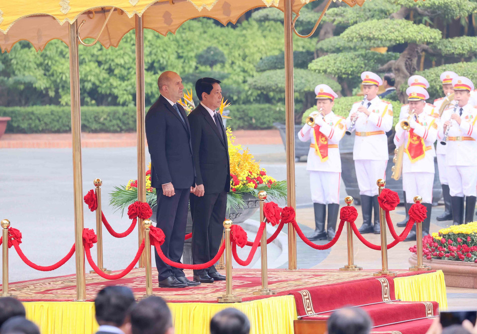 越南国家主席梁强与保加利亚总统鲁门·拉德夫登上荣誉主席台，聆听军乐奏响两国国歌。图自越通社