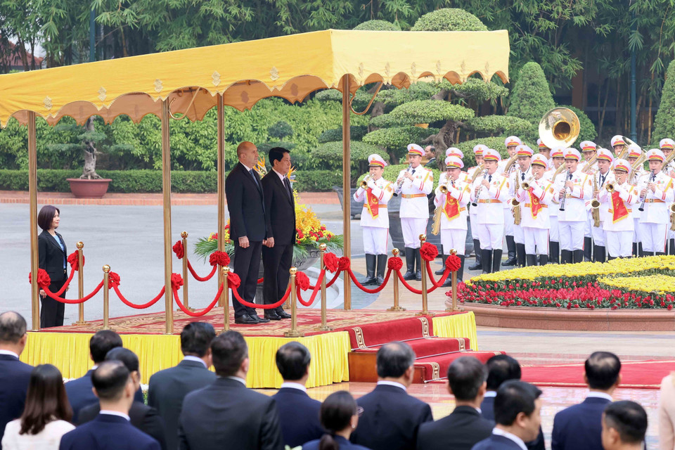 越南国家主席梁强与保加利亚总统鲁门·拉德夫登上荣誉主席台，聆听军乐奏响两国国歌。图自越通社
