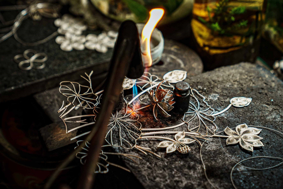 定功银饰锻制手工艺村的工匠正在焊接一幅带有许多细节和精美花纹的荷花图。图自越通社