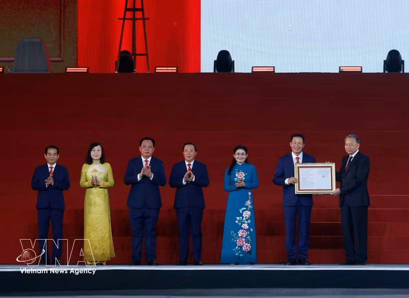 苏林代表党和国家领导人，向同奈市党委、政府和人民颁发了国会关于成立同奈市的决议。图自越通社