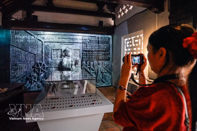 参观者参观“青史留名”展览，该展览采用传统展示形式结合数字化技术。图自越通社