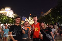 外国游客融入胡志明市市中心国庆夜晚的热闹氛围。图自越通社