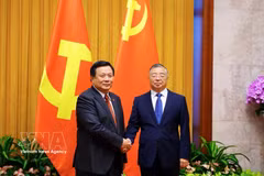 越共中央理论委员会主席、越共领导越南革命100周年总结工作指导委员会副主任阮春胜与中共中央政治局委员、书记处书记、中宣部部长李书磊在会谈上。图：越通社 