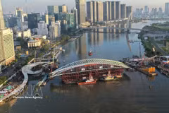 装载主跨结构的驳船就位于西贡河步行桥项目合龙位置全景图。图：越通社