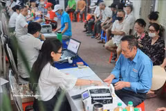 在河内市一医保支付点，邮政行业增加了服务窗口和工作人员数量，以便在人员密集时快速、便捷地完成支付工作。图自越通社 