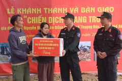 越南公安部机动警察司令部第三业务培训与职业教育中心副主任范文福上校（右二）在该中心官兵为阮廷家庭新建的住房举行落成交接后，向上德乡的阮廷一家赠送礼物并表示祝贺。图自越通社