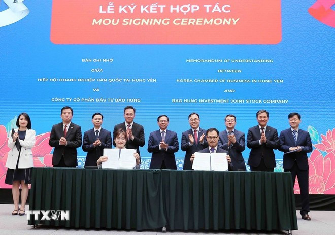 政府副总理兼外交部长裴青山与代表们一同见证韩国企业协会(兴安省)与保兴投资股份公司的合作签约仪式。图自越通社 to-lam-1.jpg