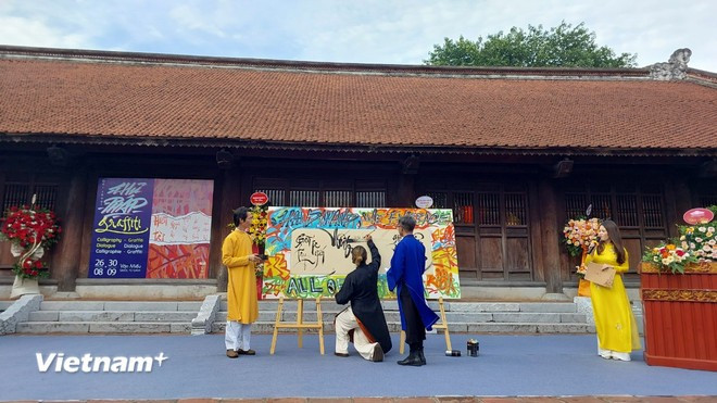 书法家们进行传统书法表演,与现代艺术的结合。(图自Vietnam+) thuphap.jpg