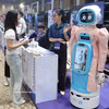 参观者在Qualcomm展台了解老年人护理机器人模型。图自越通社