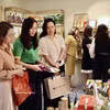 参观者在陈列展台前观看通过社交平台推广的商品。图自越通社