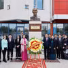 国会主席陈青敏偕夫人及代表们在以胡志明主席命名的第14学校内的胡志明主席雕像前合影留念。 图自越通社