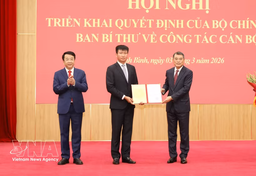 越共中央政治局委员、中央书记处书记、中央组织部部长黎明兴向陈辉俊同志颁发决定。图自越通社