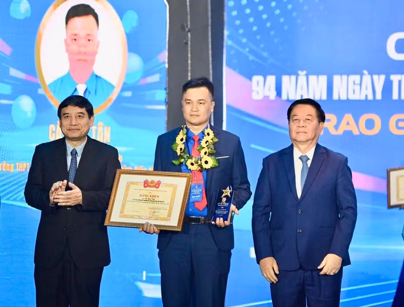 越共中央政治局委员、中央书记处书记、中央宣教与民运部部长阮仲义与越南国会文化教育委员会主任阮德荣为李自仲奖获奖者颁奖。胡志明共青团中央委员会供图