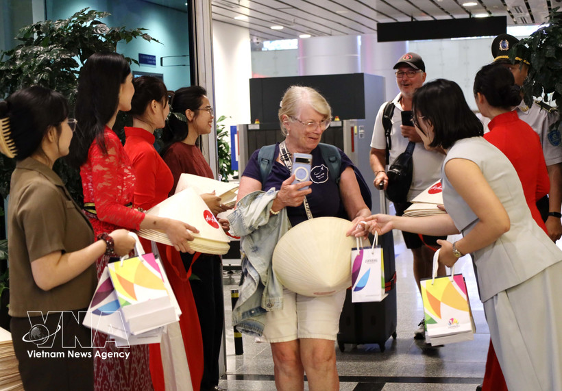 向菲律宾马尼拉和印度尼西亚巴厘岛直飞岘港市的两架航班上国际游客赠送礼物。图自越通社