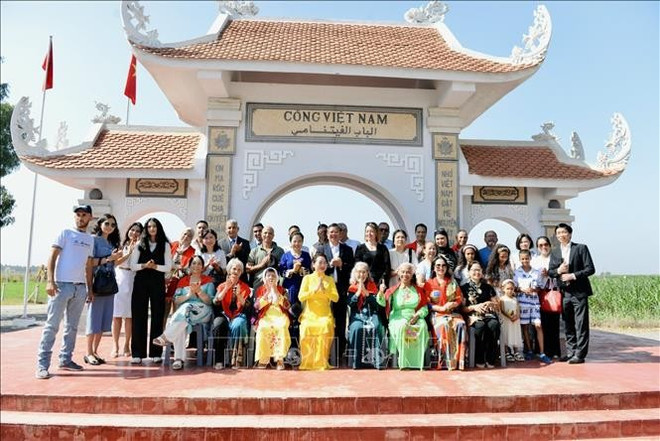 阮氏青娥夫人在越南村的门口前与越侨门合影。图自 thanh-nga-3.jpg
