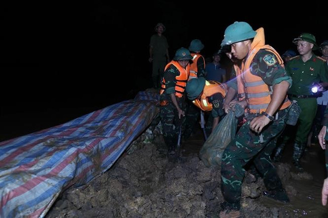 抢险力量正在加固堤防、防止洪水漫溢,确保右桥堤段安全。 图自越通社 pmc-2.jpg