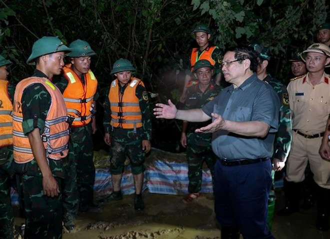 范明政总理慰问激励加固堤防、防止洪水漫溢,确保右桥堤段安全的的抢险力量。图自越通社 pmc-1.jpg